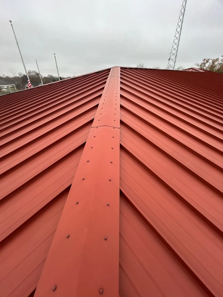 Looking at the ridge of a red metal roof on a commercial building