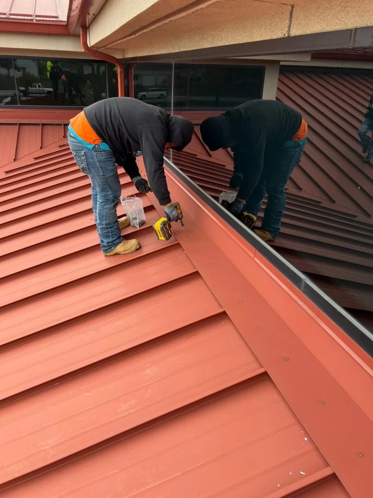 Man repairing red metal roof in Wapakoneta, Ohio