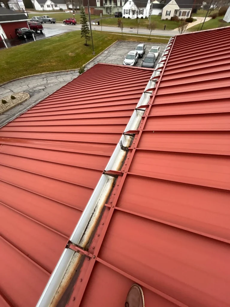 Commercial building with red metal roof being repaired in Wapakoneta, Ohio