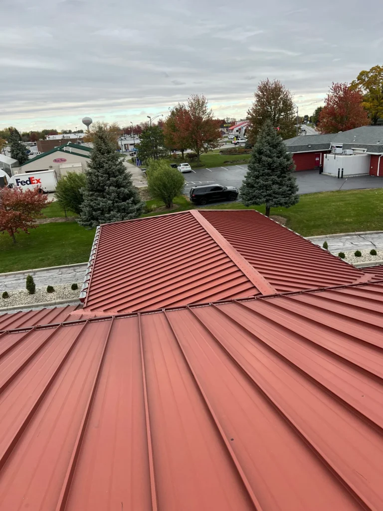 On top of a red metal roof overlooking trees and sky in Wapakoneta, Ohio.