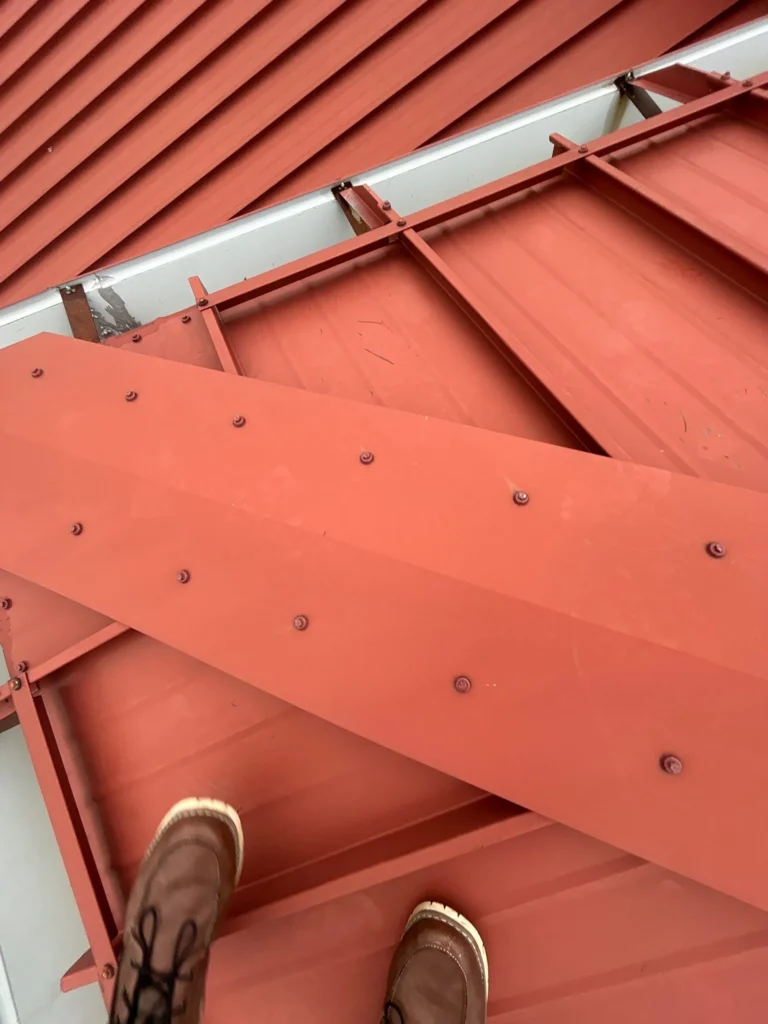 Standing over a red metal panel on a commercial roof in Wapakoneta, Ohio