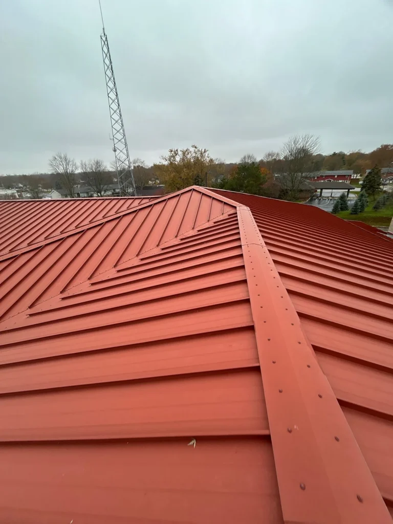 Looking across a commercial roof ridge while standing on a red metal roof